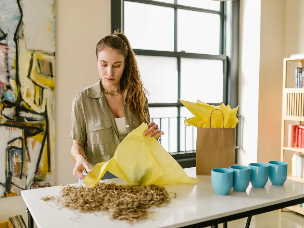 An online shop owner wrapping a product before shipping an order