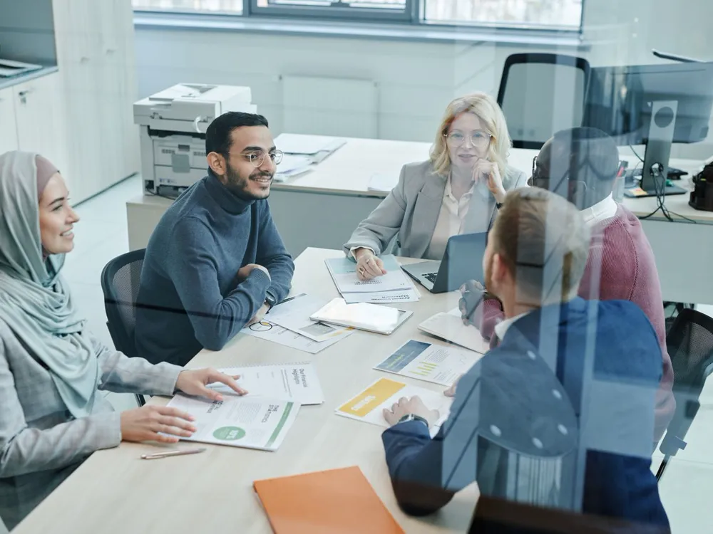 A marketing team reviewing campaign ideas around a meeting table